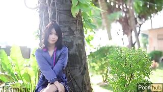 A cute Asian girl plays with her pussy in the sunny garden