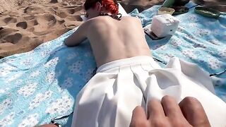 A couple has sex on the beach, enjoying the thrill of public pleasure