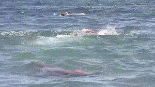 A mature woman sunbathes naked on the sandy coast