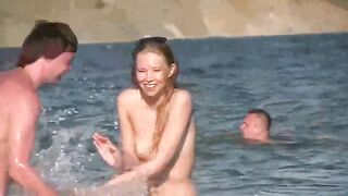 A mature woman sunbathes naked on the sandy coast