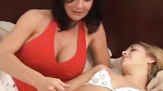 Two girls having fun and experimenting with a strap-on in the bedroom