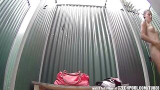 A girl has a shower and someone films her with a camera