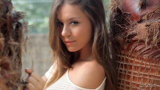 Young Russian beauty dancing erotic striptease in a beautiful dress