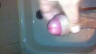 The kid caresses his dick in the shower with his hand