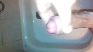 The kid caresses his dick in the shower with his hand