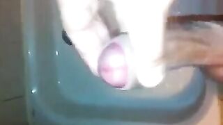The kid caresses his dick in the shower with his hand