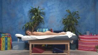 A young masseuse gives an erotic massage to her client with oil