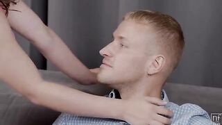 A man is giving himself to a girl on the couch in a sensual act